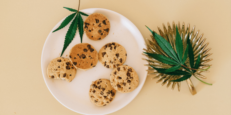 Cannabis leaves and cookies representing cannabinoid-infused consumer food products