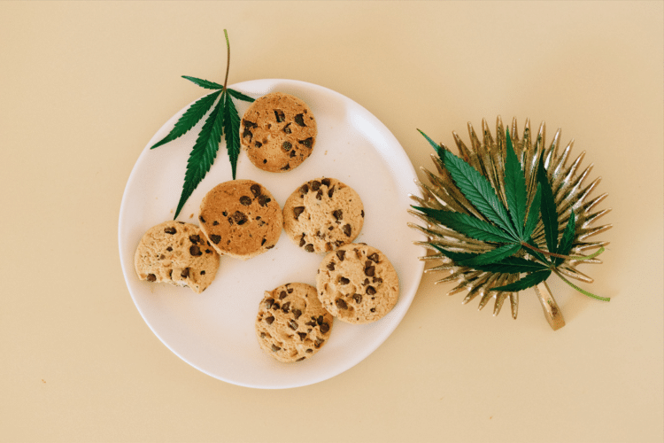 Cannabis leaves and cookies representing cannabinoid-infused consumer food products