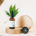 Hemp-derived CBD oil and topical product containers displayed with hemp leaves on a wooden platform
