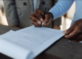 Business professionals reviewing and signing regulatory documents