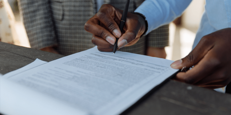 Business professionals reviewing and signing regulatory documents
