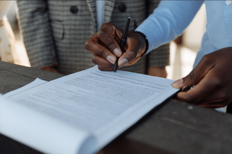 Business professionals reviewing and signing regulatory documents