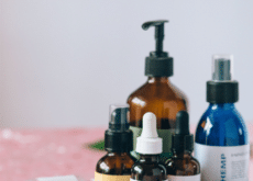 Hemp-derived CBD oils, topical creams, capsules, and other cannabinoid wellness products arranged on a pink surface.