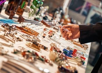 Tube vaporizer for marijuana. Device for smoking marijuana. Exhibition of handmade tools. Man's hand holding glass vaporizer..