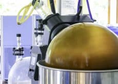 Industrial hybrid ultrasound-microwave extraction system showing 300% yield increase in modern botanical processing facility